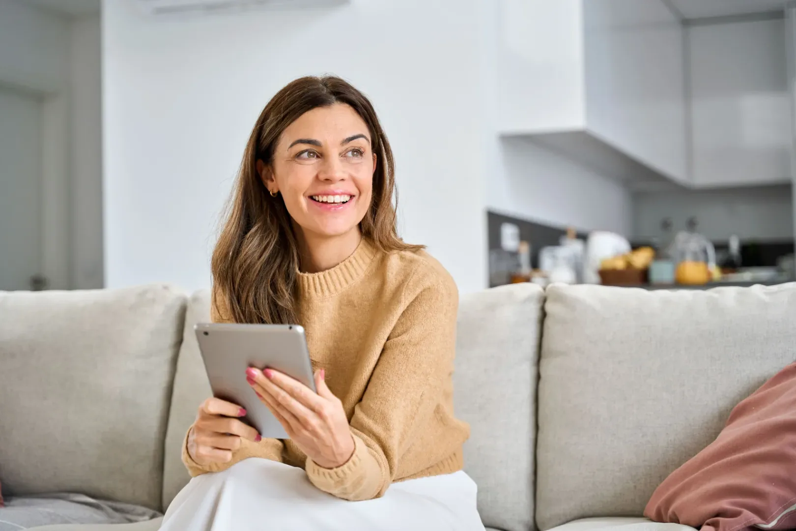 An editor smiling while reading on a tablet
