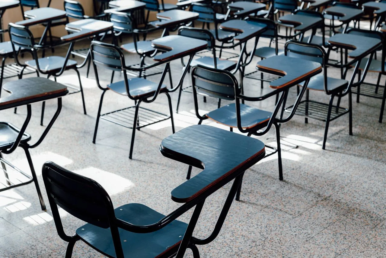Rows of empty classroom desks before term