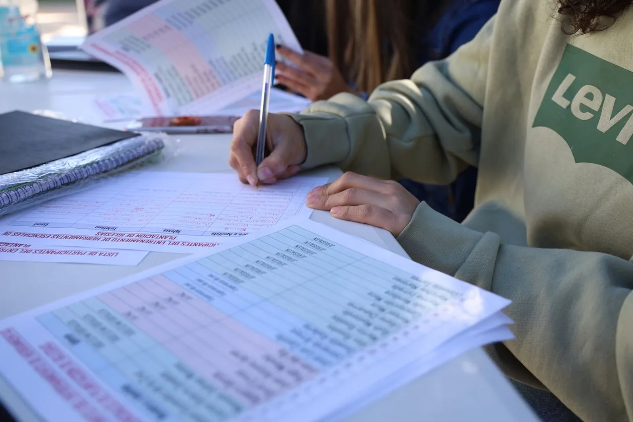 A student completing an enrolment form with a pen