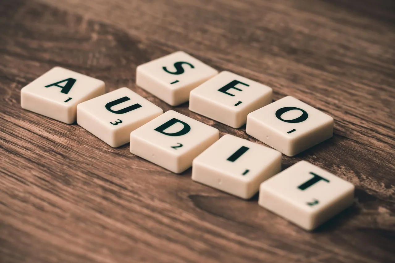 Letter tiles spelling SEO audit on a wooden desk