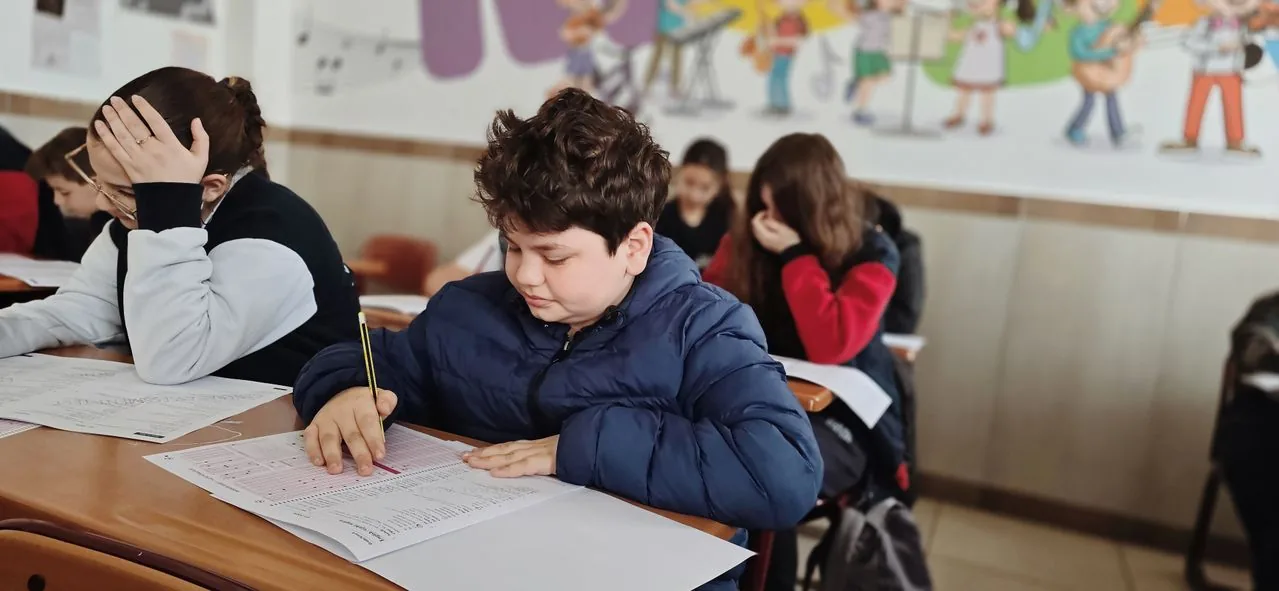 Students at classroom desks filling in enrolment paperwork